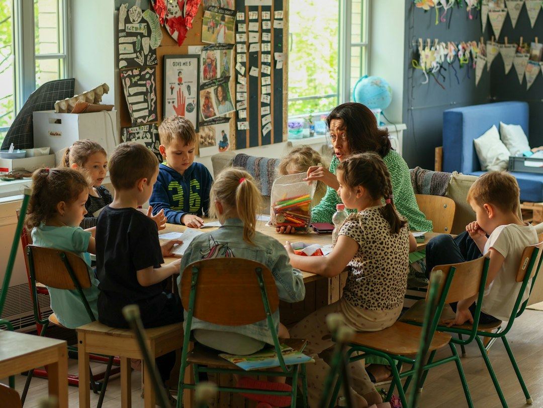 A teacher and children working together around a classroom activity table.