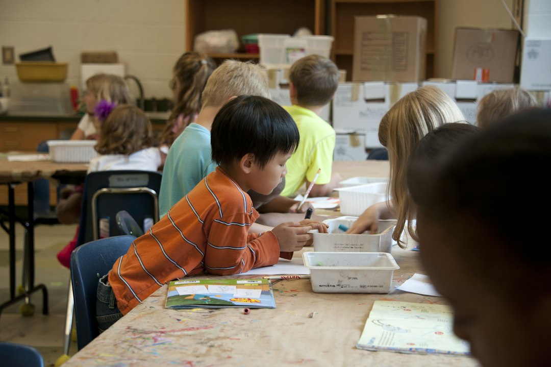 Children drawing and choosing crayons together in a classroom.